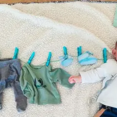 Un bebé de 5 meses celebra su mes con ropa colgada.