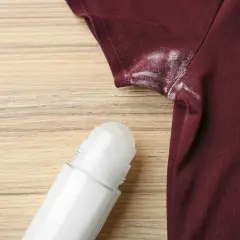 Manchas blancas de desodorante en una camiseta granate, un problema común que puede desteñir ropa.
