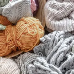 Ovillos de lana y tejidos en tonos grises, ocres y verdes. Una muestra de la suavidad y calidez que ofrece la alpaca textil.
