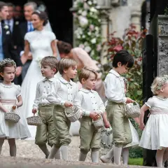Niños y niñas con trajes de época, portando cestas, son pajes en una boda.