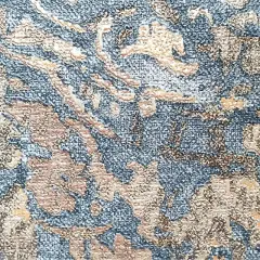 Textura de tela con patrón floral en relieve, un ejemplo de que es el jacquard, en tonos azules y beige.