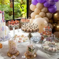 Mesa dulce para comunión: tarta de tres pisos, cupcakes, postres individuales y globos. ¡Ideas para organizar una comunión inolvidable!