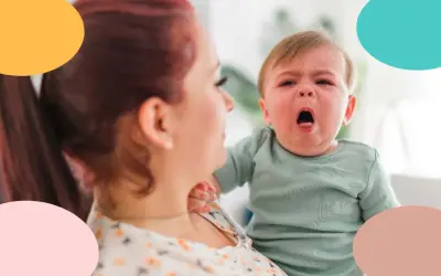 Bebé con tos, llorando en brazos de su madre.