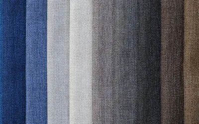 Muestras de tejido damasco en tonos azules, grises y marrones, con texturas visibles.