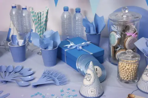 Decoración azul para un baby shower: significado de celebración y bienvenida. Vasos, platos, botellas, galletas y un regalo.