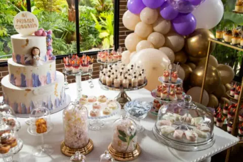 Mesa dulce para comunión: tarta de tres pisos, cupcakes, postres individuales y globos. ¡Ideas para organizar una comunión inolvidable!