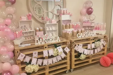 Mesa dulce casera para comunión de niña con globos rosas y blancos, dulces y decoraciones personalizadas. ¡Un festín inolvidable!