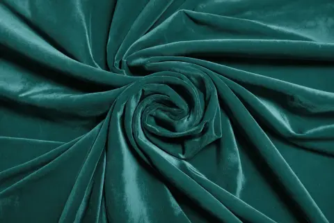 Terciopelo verde azulado con pliegues que forman un remolino. Aprende como arreglar terciopelo chafado para restaurar su suavidad.