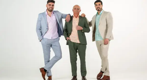 Tres hombres con trajes de lino, listos para ser invitados a una comunión.