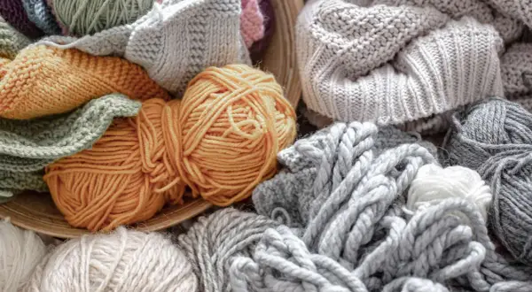 Ovillos de lana y tejidos en tonos grises, ocres y verdes. Una muestra de la suavidad y calidez que ofrece la alpaca textil.