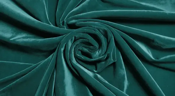 Terciopelo verde azulado con pliegues que forman un remolino. Aprende como arreglar terciopelo chafado para restaurar su suavidad.