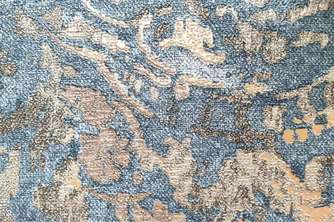 Textura de tela con patrón floral en relieve, un ejemplo de que es el jacquard, en tonos azules y beige.