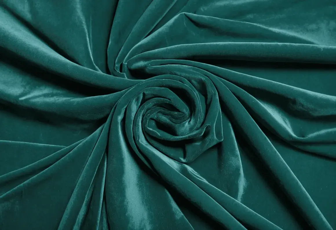 Terciopelo verde azulado con pliegues que forman un remolino. Aprende como arreglar terciopelo chafado para restaurar su suavidad.