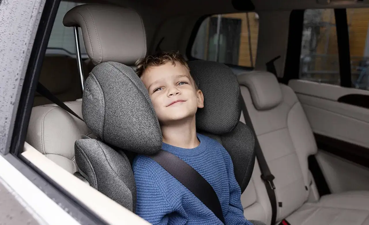 Ni&ntilde;o sonriente en silla de auto, seguro. &iquest;Hasta qu&eacute; edad los ni&ntilde;os deben usar silla de auto? La seguridad es lo primero.