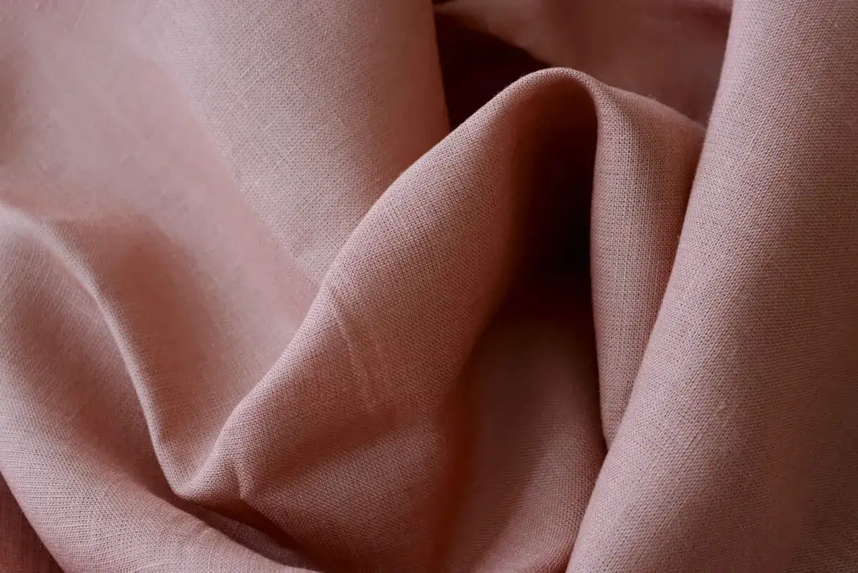 Textura suave y arrugada de tela de lino rosa p&aacute;lido. El lino da calor y confort, ideal para prendas de vestir.