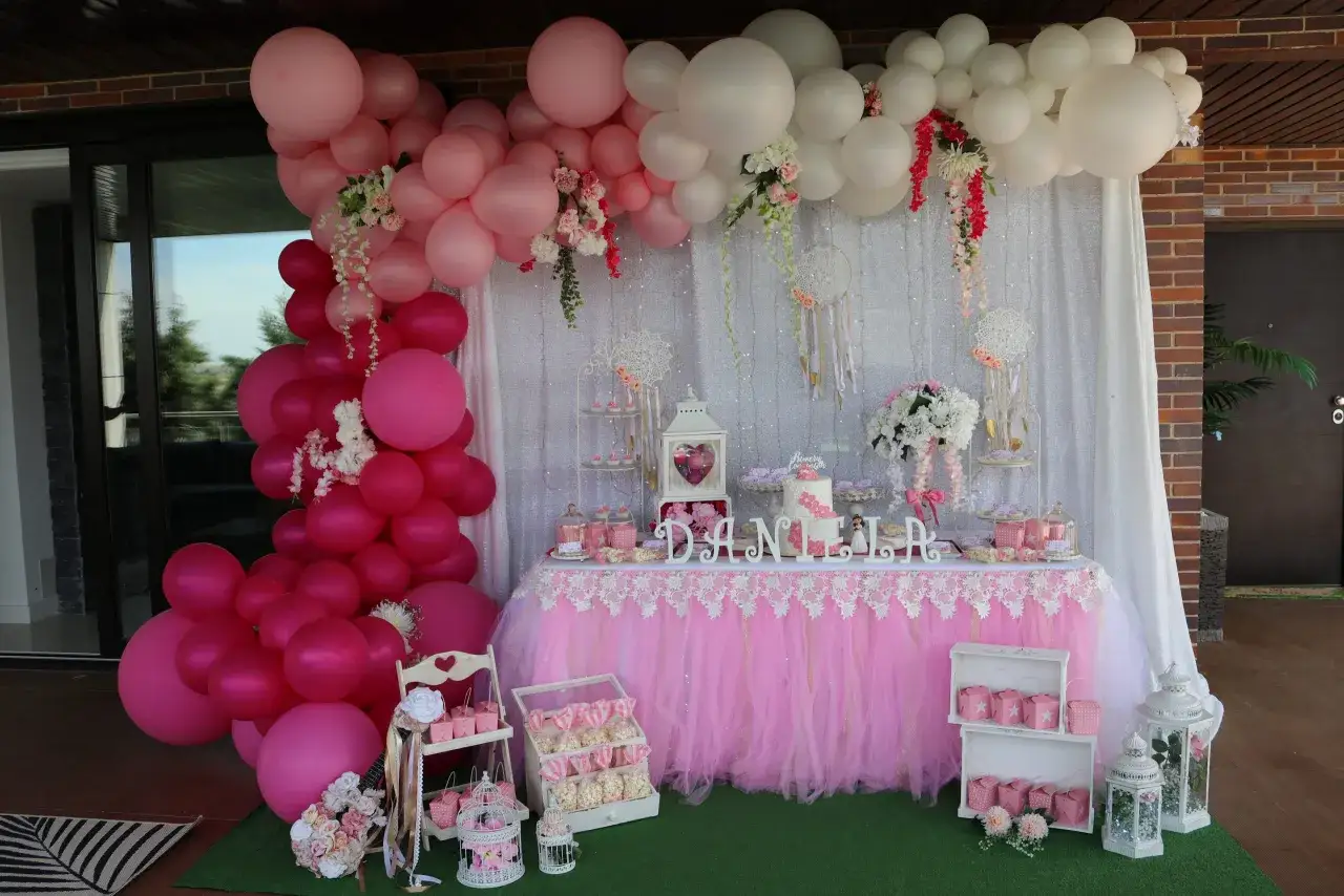 Preciosa decoraci&oacute;n comuni&oacute;n ni&ntilde;a casera con globos rosas y blancos, mesa dulce y detalles encantadores.