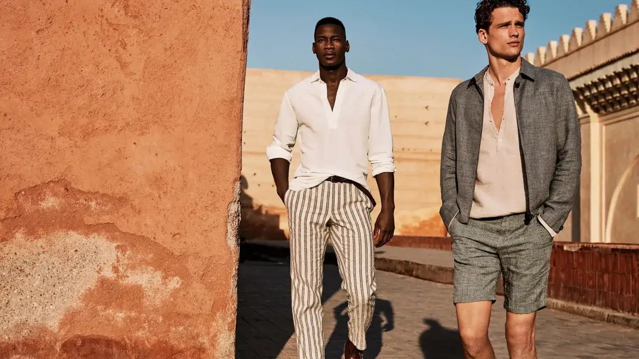 Dos hombres con atuendos veraniegos, perfectos para saber como ir a un bautizo informal hombre verano.