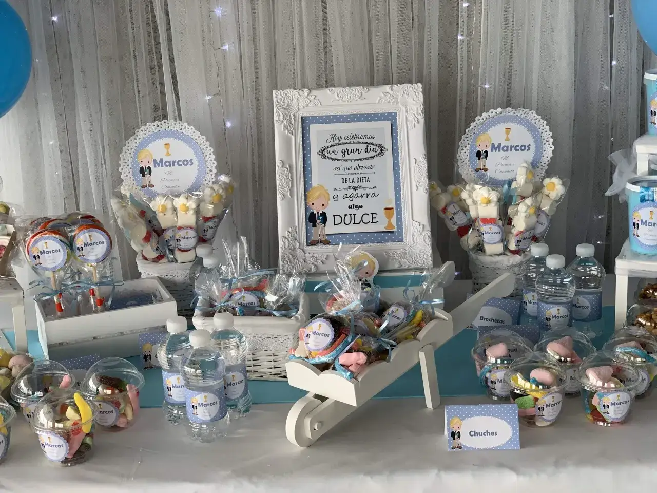 Ideas mesas dulces comuni&oacute;n ni&ntilde;o: mesa tem&aacute;tica de comuni&oacute;n para Marcos con caramelos, piruletas y brochetas, todo decorado con motivos infantiles.