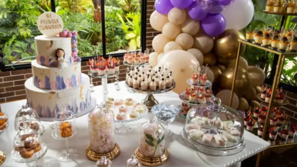 Mesa dulce para comunión: tarta de tres pisos, cupcakes, postres individuales y globos. ¡Ideas para organizar una comunión inolvidable!