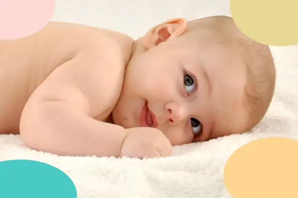 Bebé de 8 meses, en plena crisis, mira con curiosidad. Suave piel y ojos grandes sobre una toalla blanca.